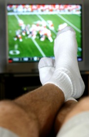 A Man Watching a Football Game on TV